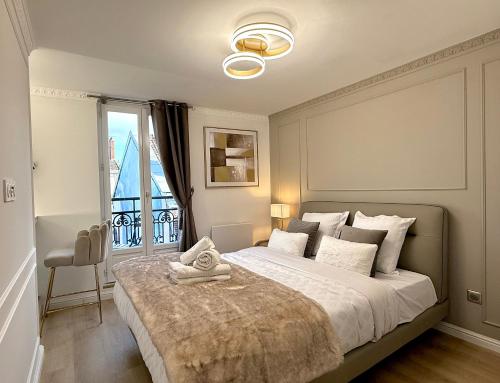 een slaapkamer met een groot bed en een raam bij Résidence Auguste Comte - avec Balcon - Cœur de Dijon in Dijon