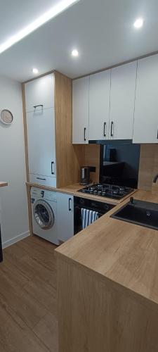 ラチブシュにあるApartament MiKaTyのキッチン(白いキャビネット、洗濯機付)