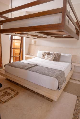 a bedroom with a bunk bed with white sheets at Casa Astral Hotel Boutique and Apartments in Holbox Island