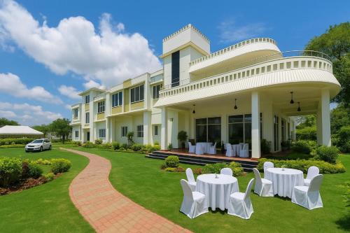 a building with white chairs and tables on the lawn at Siya Resort Ayodhya - Comfortable Rooms & Luxury Stay Near Ram Mandir in Ayodhya