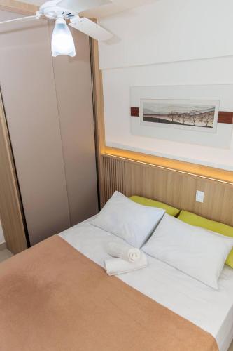 a bed with white pillows in a room at 250m from the Sea | Pool and Bed Linens in Bertioga