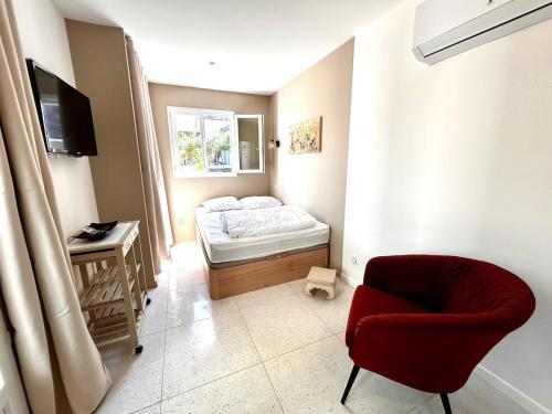 a small room with a bed and a chair at Les Gîtes du Petit Bois CHEVREFEUILLE in Ruoms