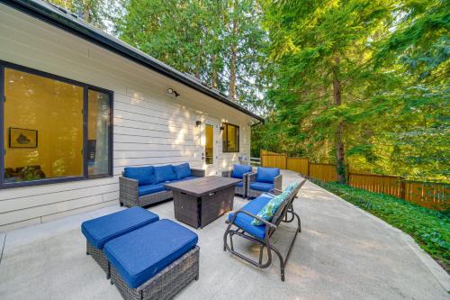 a patio with blue cushioned chairs and a table at WFH-Friendly Gem with Creek 4 Mi to Sammamish Trail in Redmond