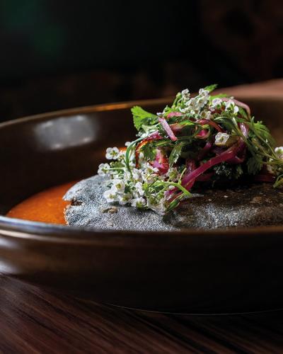 a bowl of soup with vegetables on a table at Casa de la Luz Hotel Boutique in Mexico City