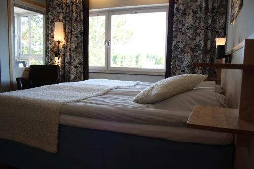 a bedroom with a large bed with a window at Sankt Olof Hotell & Krog in Malung