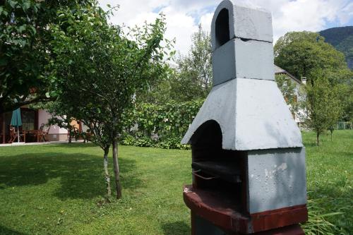 an outdoor oven sitting in a yard next to a tree at Apartments Kravanja in Bovec