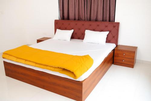 a bedroom with a large bed with a yellow blanket at EMPYREAN STAY II 6BHK II FLAGSHIP VILLA II AC II PVT POOL ll LAWN ll TERRACE in Lonavala