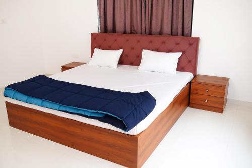 a bedroom with a large bed with a wooden frame at EMPYREAN STAY II 6BHK II FLAGSHIP VILLA II AC II PVT POOL ll LAWN ll TERRACE in Lonavala