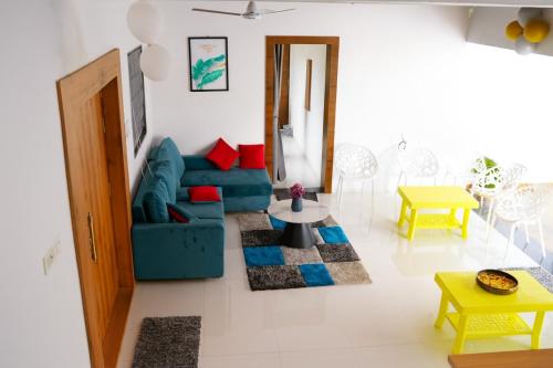 a living room with a blue couch and a table at EMPYREAN STAY II 6BHK II FLAGSHIP VILLA II AC II PVT POOL ll LAWN ll TERRACE in Lonavala