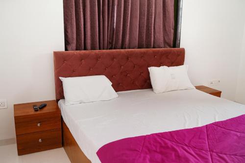 a bed with a red headboard in a room at EMPYREAN STAY II 6BHK II FLAGSHIP VILLA II AC II PVT POOL ll LAWN ll TERRACE in Lonavala