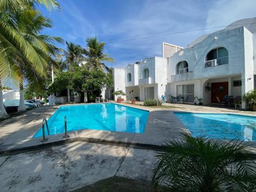 a swimming pool in front of a house at Family Apartment 2 Bedrooms Pool 2 Blocks from the Beach in Cedro