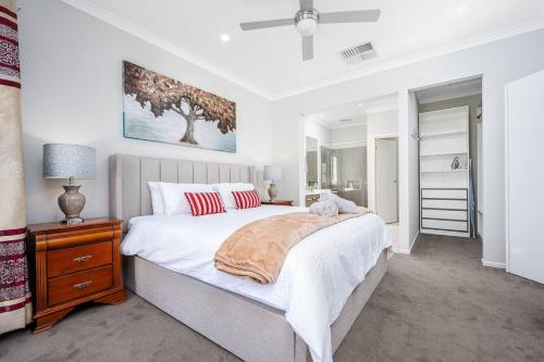 a bedroom with a large bed with white sheets and red pillows at Cloverlea Spacious 4BR Yarra Valley Getaway in Lilydale