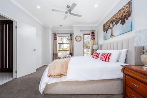 a bedroom with a white bed and a ceiling fan at Cloverlea Spacious 4BR Yarra Valley Getaway in Lilydale