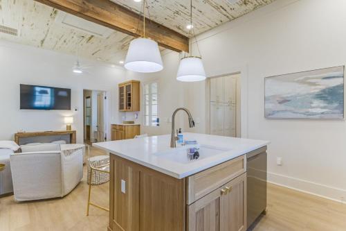 a kitchen with a sink and a living room at Chelles in Bay St. Louis in Bay Saint Louis