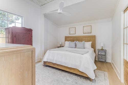 a white bedroom with a bed and a window at Chelles in Bay St. Louis in Bay Saint Louis