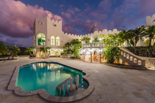 un resort con piscina di fronte a un edificio di Castle St Croix a Christiansted