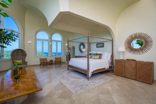 una camera da letto con un letto a baldacchino in una stanza con finestre di Castle St Croix a Christiansted