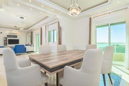 a dining room with a wooden table and white chairs at Glint 3-Bedroom Apartment & Balcony in Aley in Aley