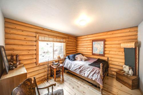a bedroom with wooden walls and a bed and a television at Cascade Log Cabin by Casago McCall - Donerightmanagement in Cascade