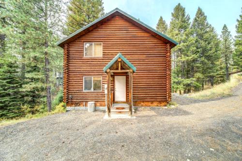 a wooden cabin with a door in the woods at Cascade Log Cabin by Casago McCall - Donerightmanagement in Cascade