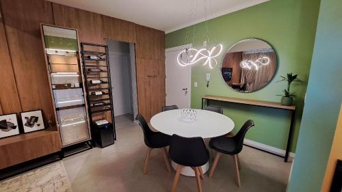 ein Esszimmer mit einem weißen Tisch und schwarzen Stühlen in der Unterkunft Apto Novo próximo Maria Fumaça in Bento Gonçalves