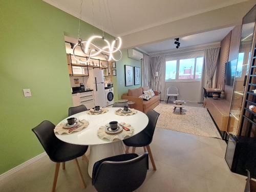 eine Küche und ein Wohnzimmer mit Tisch und Stühlen in der Unterkunft Apto Novo próximo Maria Fumaça in Bento Gonçalves
