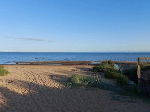 a sandy beach with the ocean in the background at 4 star holiday home in Halmstad in Halmstad
