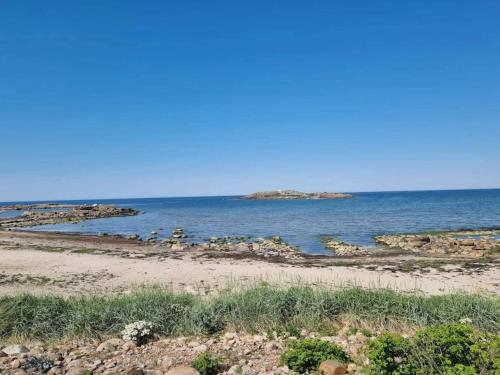 a beach with an island in the water at 4 star holiday home in Halmstad in Halmstad