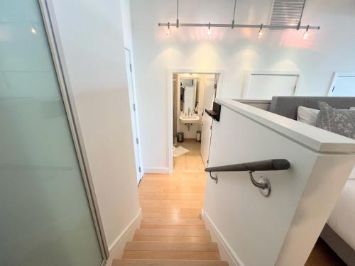 ein Flur mit einer weißen Theke und eine Treppe mit einem Spiegel in der Unterkunft The Crestwood Loft 2BR 3Beds in Odricks Corner