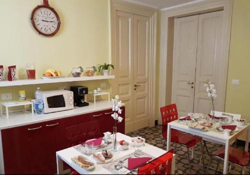 una cucina con un tavolo e un orologio a parete di Central Suites Catania a Catania