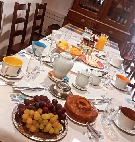 a table with a plate of fruit on a table with tea at Casa de l' Eigreija 