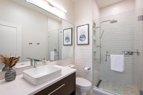 Un baño blanco con lavabo y ducha. en The Chic Hideaway, en Baptist Hospital Heliport