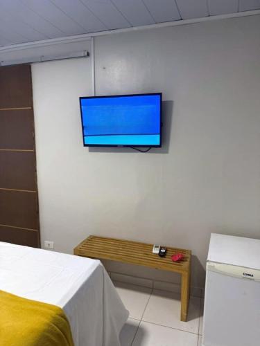 a flat screen tv hanging on a wall in a bedroom at Pousada do Trinta in Fernando de Noronha