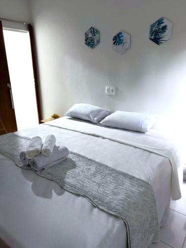 a bedroom with a white bed with towels on it at Pousada do Trinta in Fernando de Noronha