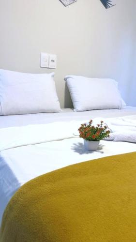 a white bed with a potted plant on top of it at Pousada do Trinta in Fernando de Noronha
