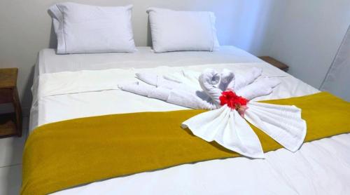a white bed with a yellow and white blanket at Pousada do Trinta in Fernando de Noronha