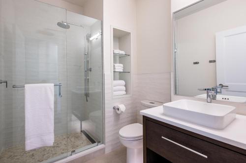 Un baño con lavabo y ducha de cristal. en Downtown Loft on Palafox Street, en Baptist Hospital Heliport