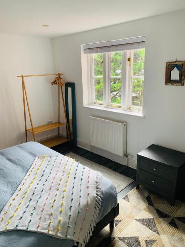 a bedroom with a bed and a window at Glastonbury town centre modern apartment in Glastonbury