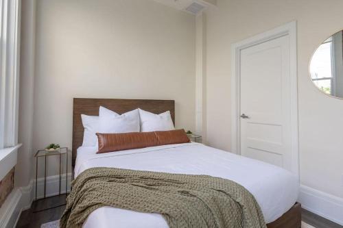 een slaapkamer met een wit bed en een bruin kussen bij Chestnut Chateau in Baptist Hospital Heliport