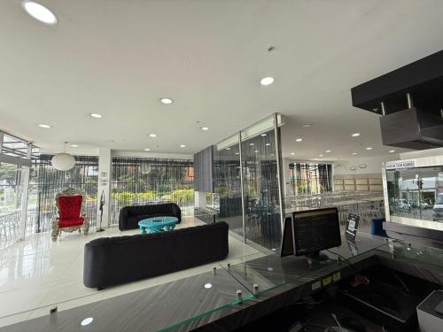 a large living room with a couch and a tv at Hotel Plaza Sport in Bogotá