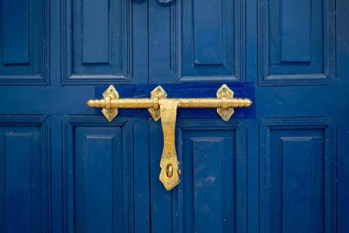 a gold cross hanging on a blue door at Palmeraie Tradition and Modernity in Marrakech