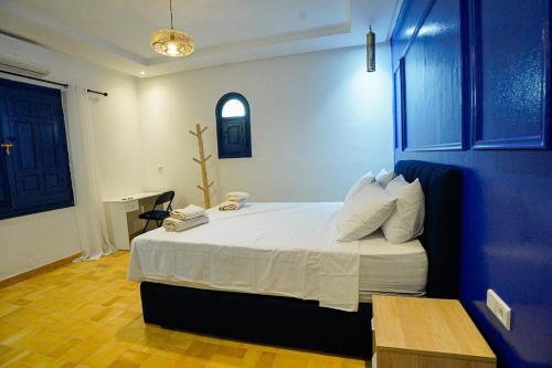a bedroom with a large bed with a blue wall at Palmeraie Tradition and Modernity in Marrakech