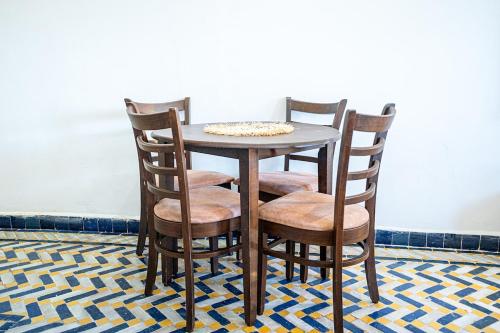 a wooden table with four chairs and a table at Palmeraie Tradition and Modernity in Marrakech