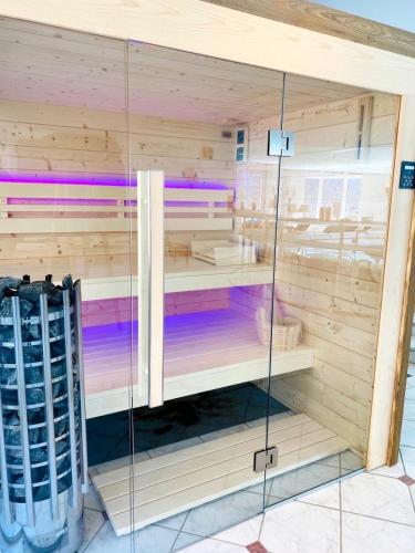 a sauna with wooden walls and a glass door at The Alpine No 7 in Reith bei Seefeld