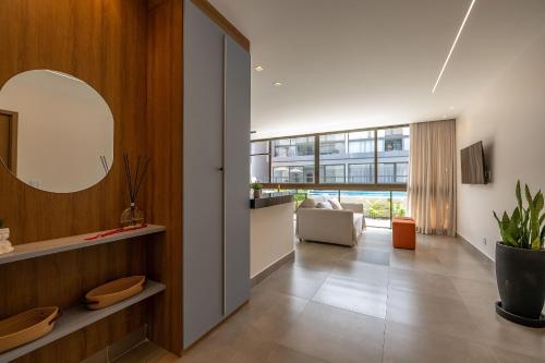 バーハ・グランデにあるSeu refúgio à poucos passos da Praia e da Vila!のリビングルーム(鏡、ソファ付)