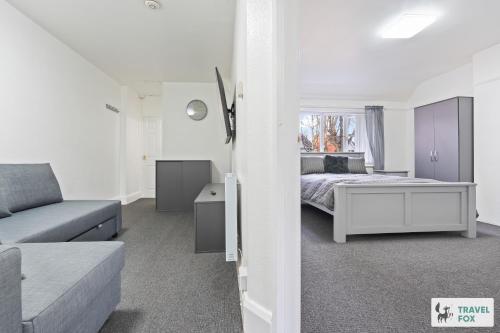 a white bedroom with a bed and a couch at Abbie's House in Nottingham