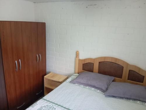 a bedroom with a wooden bed and wooden cabinets at Departamentos y tinajas Blanquita mahuida in El Quisco