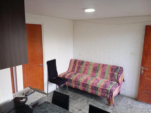 a living room with a couch and a chair at Departamentos y tinajas Blanquita mahuida in El Quisco