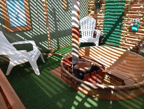 a porch with a swing and a table and chairs at Departamentos y tinajas Blanquita mahuida in El Quisco
