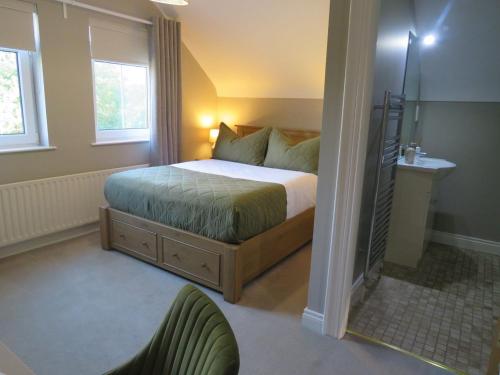 a bedroom with a bed and a chair in it at Maine House Galgorm in Ballymena
